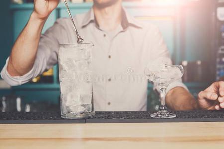 酒吧间销售酒精饮料的人制造冰为鸡尾酒特写镜头照片
